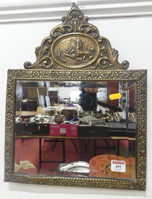 Lot 492 - A Dutch repousse decorated brass framed wall...