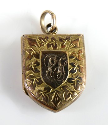 Lot 2325 - A yellow metal engraved shield shaped locket...