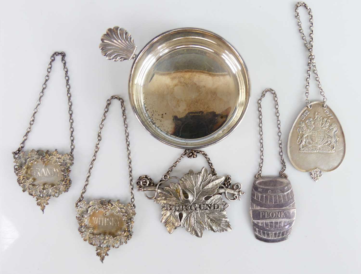 Lot 2102 - A collection of five silver decanter collars,...