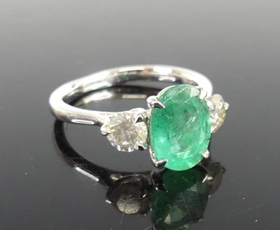 Lot 2332 - A platinum, emerald and diamond three-stone...