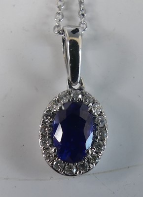 Lot 2303 - An 18ct white gold, sapphire and diamond oval...