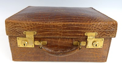 Lot 140 - A 1920s crocodile skin suitcase, having gilt...