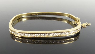 Lot 2319 - A yellow metal diamond set hinged bangle,...
