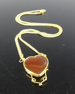 Lot 2280 - A yellow metal heart shaped carnelian pendant,...