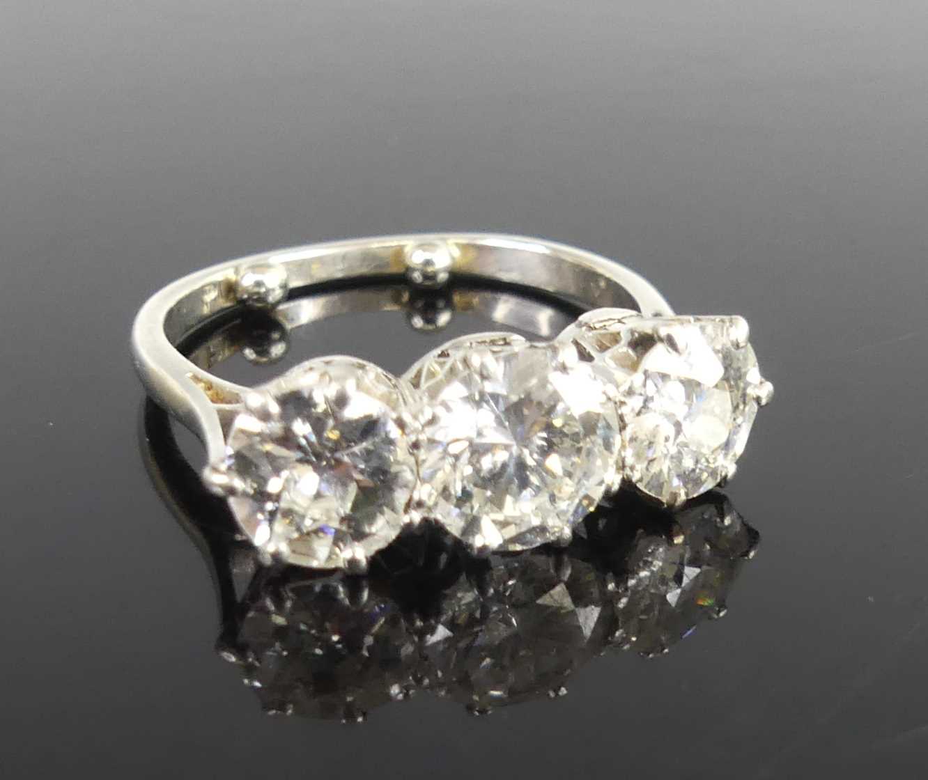 Lot 2359 - A platinum diamond set trilogy ring, arranged...