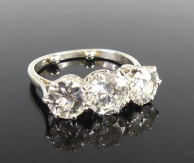 Lot 2359 - A platinum diamond set trilogy ring, arranged...