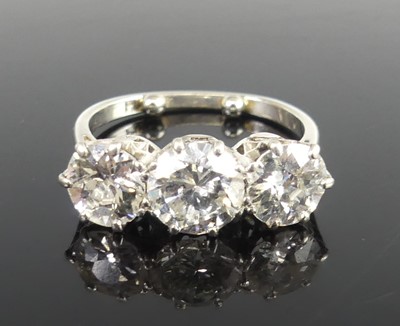 Lot 2359 - A platinum diamond set trilogy ring, arranged...