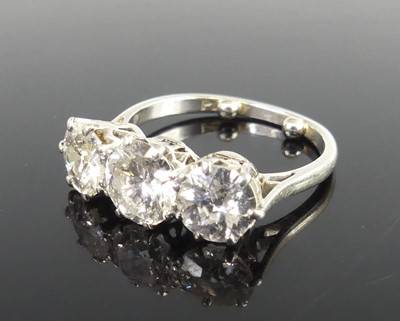 Lot 2359 - A platinum diamond set trilogy ring, arranged...