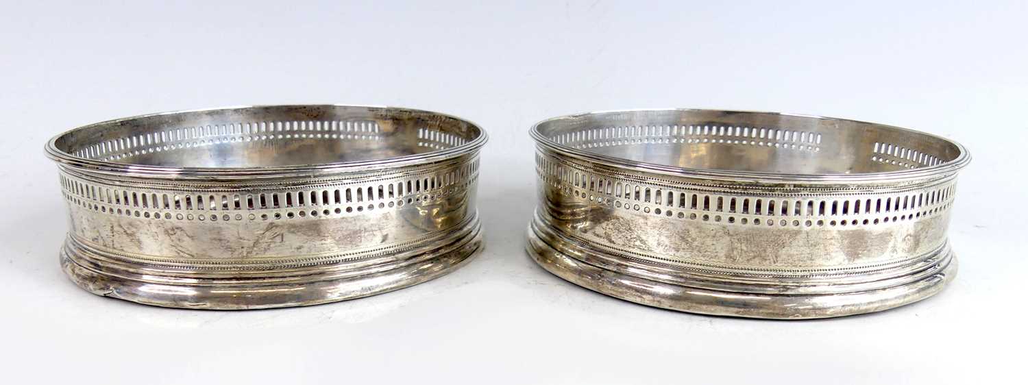 Lot 2109 - A pair of George III silver wine bottle...