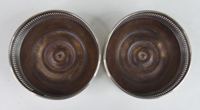 Lot 2109 - A pair of George III silver wine bottle...