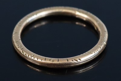 Lot 307 - A carved yellow metal band ring, unmarked but...