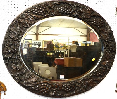 Lot 1113 - A floral and vine relief carved oak oval...