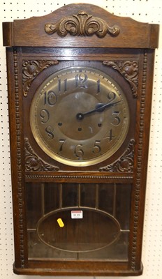 Lot 1118 - A 1930s oak droptrunk wall clock, with pendulum