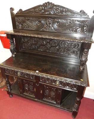 Lot 1156 - An ebonised oak and relief carved buffet side...