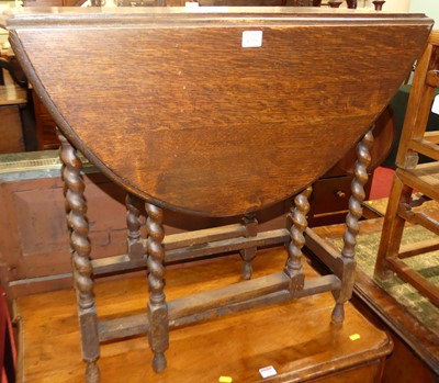 Lot 1259 - A 1920s oak barley twist gateleg drop leaf...