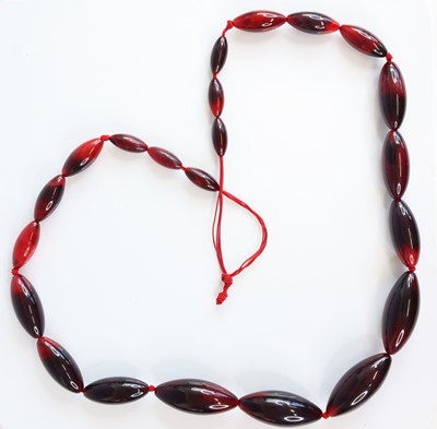 Lot 368 - A faux cherry amber necklace, arranged as 22...