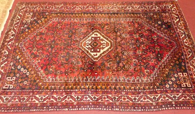 Lot 1138 - A Persian woollen red ground Shiraz rug, 250 x...