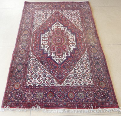 Lot 1141 - A Persian woollen red and cream ground Heriz...