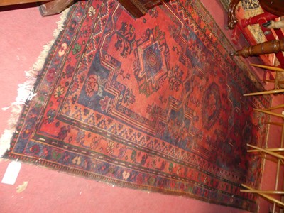 Lot 1144 - A Persian woollen red and deep blue ground...