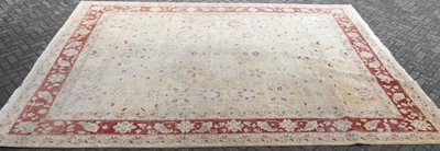 Lot 1324 - A large Turkish cream and red ground rug, with...