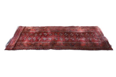 Lot 1143 - A red Afghan runner, with a repeating...