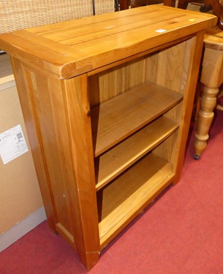 Lot 1217 - A small joined blond oak low open bookshelf,...