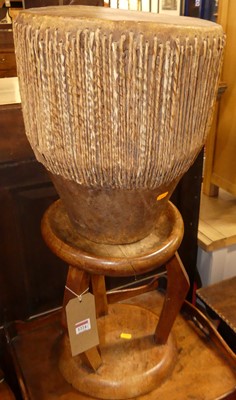Lot 1224 - A tribal drum, together with a further tribal...