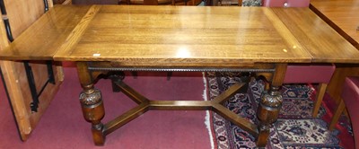 Lot 1252 - A joined oak draw-leaf dining table, the plank...