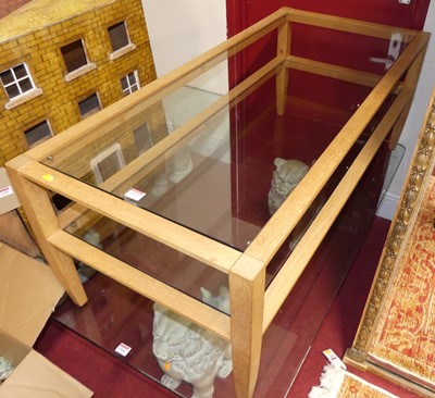 Lot 1343 - A contemporary Ercol blond oak and glass inset...