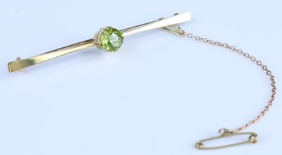 Lot 361 - A yellow metal peridot bar brooch with a...