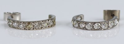 Lot 2673 - A pair of white metal diamond half hoop...