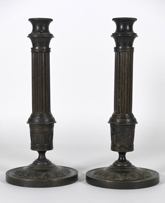 Lot 42 - A pair of bronze table candlesticks, in the...
