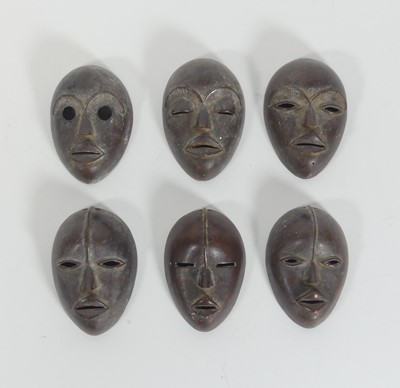 Lot 314 - A set of six African bronze masks, h.10.5cm