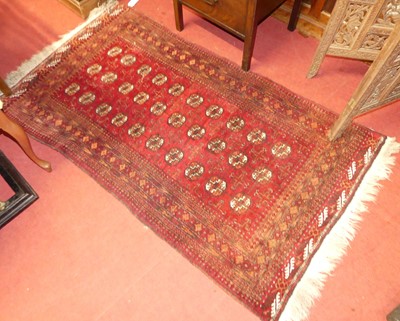 Lot 1186 - A Persian woollen red ground Bokhara rug,...