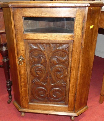 Lot 1233 - A low oak single door corner cupboard, h.78cm