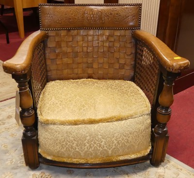 Lot 1303 - A walnut leather and cane bergere armchair,...