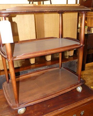 Lot 1380 - An Ercol dark elm three-tier tea trolley, on...