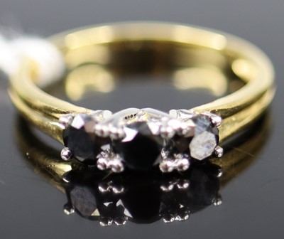 Lot 355 - A yellow metal black diamond three-stone ring,...