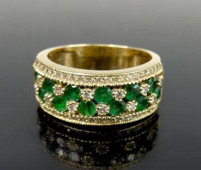 Lot 2591 - A yellow metal four-row emerald and diamond...