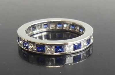 Lot 2595 - A white metal, sapphire and diamond eternity...