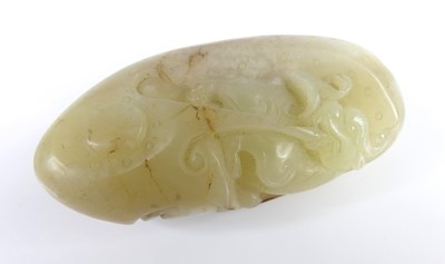 Lot 39 - A Chinese celadon and russet carved jade...