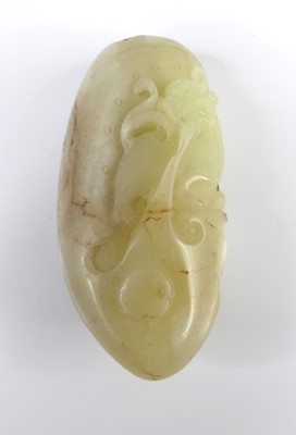 Lot 39 - A Chinese celadon and russet carved jade...