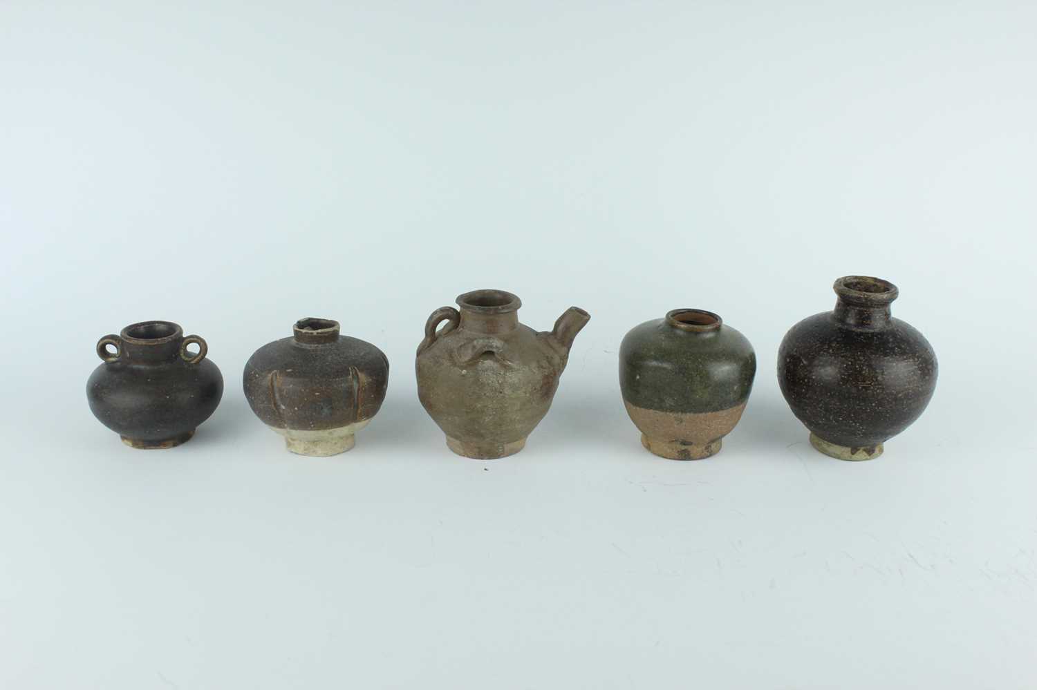 Lot 121 - Five small Chinese black-glazed stoneware pots,...