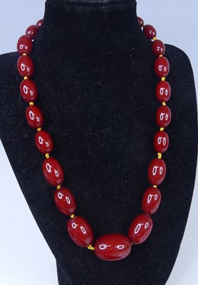 Lot 2611 - A cherry amber necklace, arranged as 25...