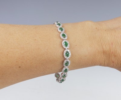 Lot 2801 - An 18ct white gold, emerald and diamond line...