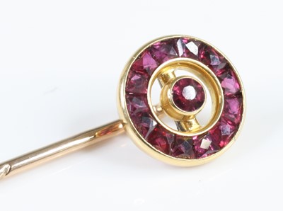 Lot 2823 - A yellow metal ruby stick pin, featuring a...