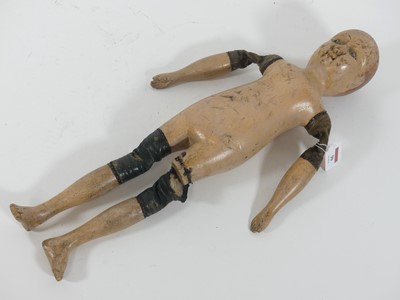 Lot 90 - A carved and painted wooden doll, having...