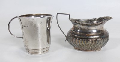 Lot 194 - A George V silver milk jug of half reeded oval...