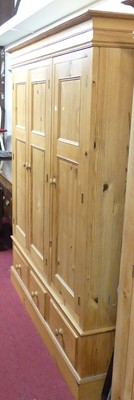 Lot 1145 - A contemporary pine three door wardrobe,...