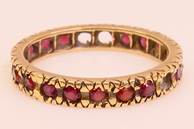 Lot 252 - A yellow metal garnet set eternity ring (one...